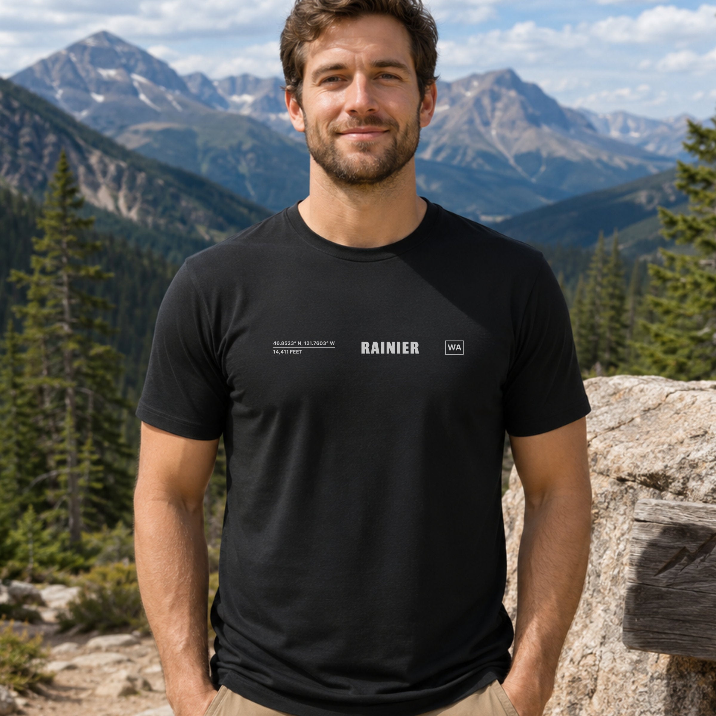 Man wearing a black t-shirt with small chest text in a mountain setting